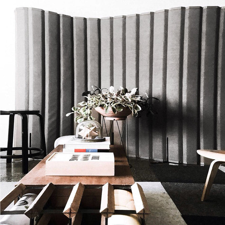 Grey acoustical versipanel partition in a lobby environment with chairs coffee tables and plants